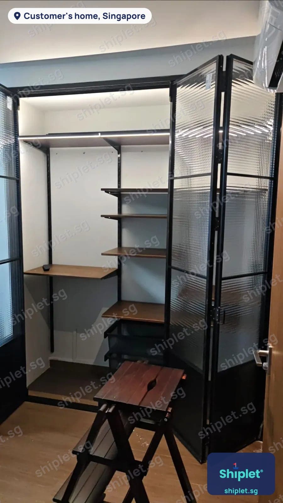 Bifold fluted glass wardrobe doors with shelves and pull-out drawers inside, installed in a bedroom