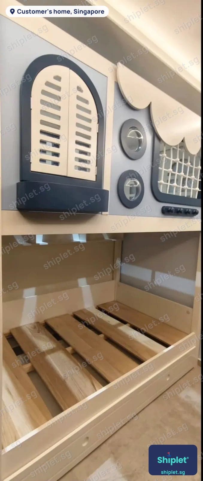 Children's bunk bed with a boat-themed play front, shutters and portholes, assembled in a bedroom