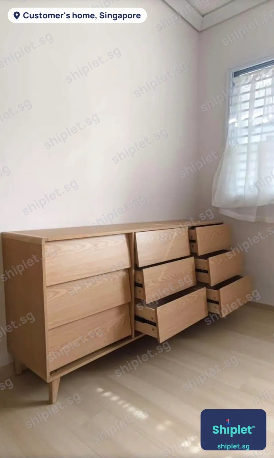 Nine-drawer ash chest of drawers assembled in a bedroom with the drawers pulled open