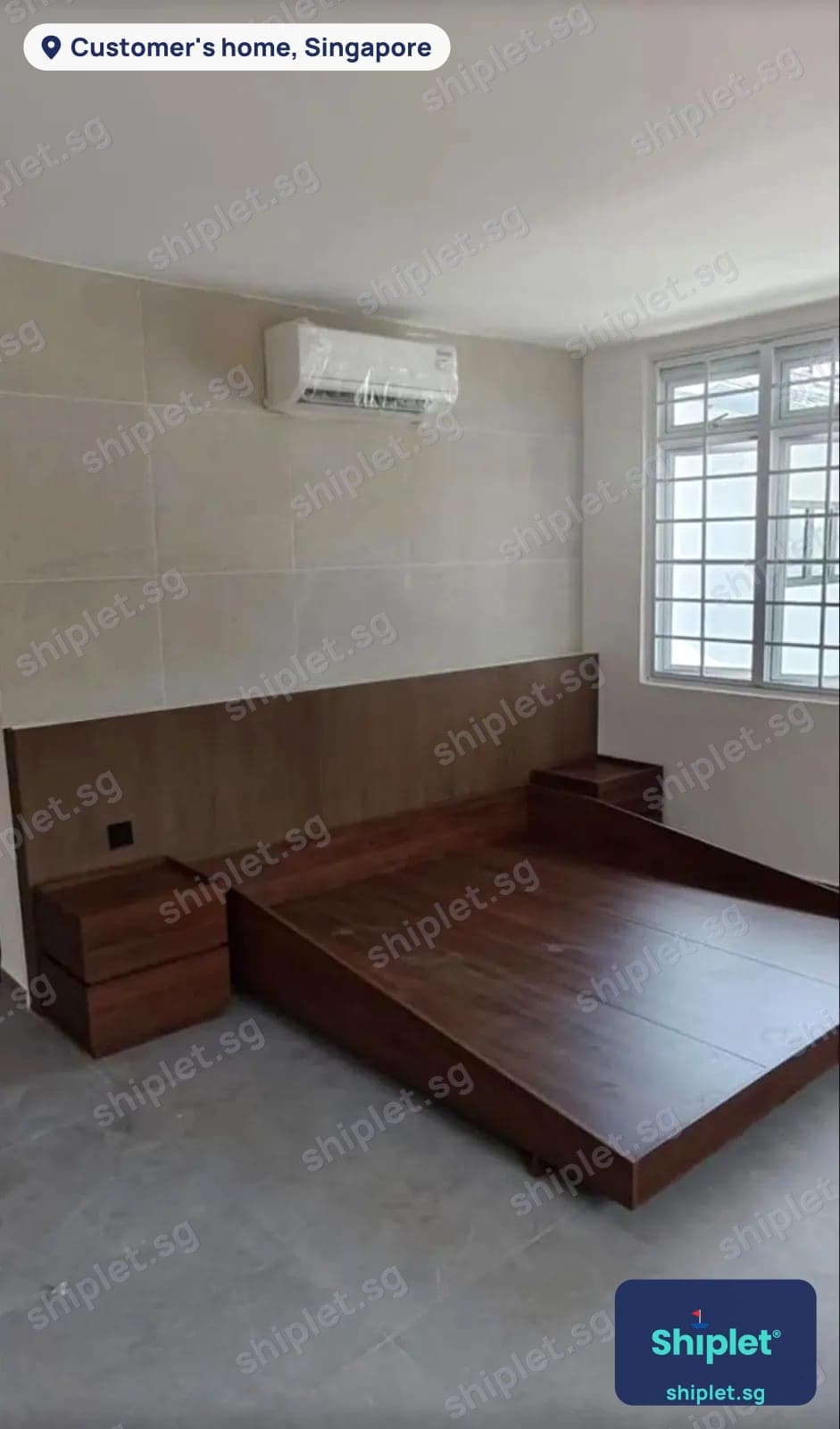 Platform bed with a wall-to-wall headboard panel and two bedside drawer units assembled in a bedroom