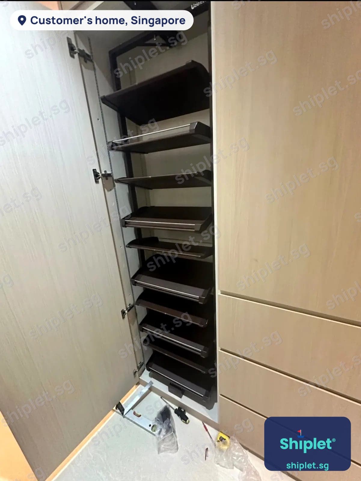 Pull-out shoe rack with nine tilting shelves fitted inside a tall laminate cabinet