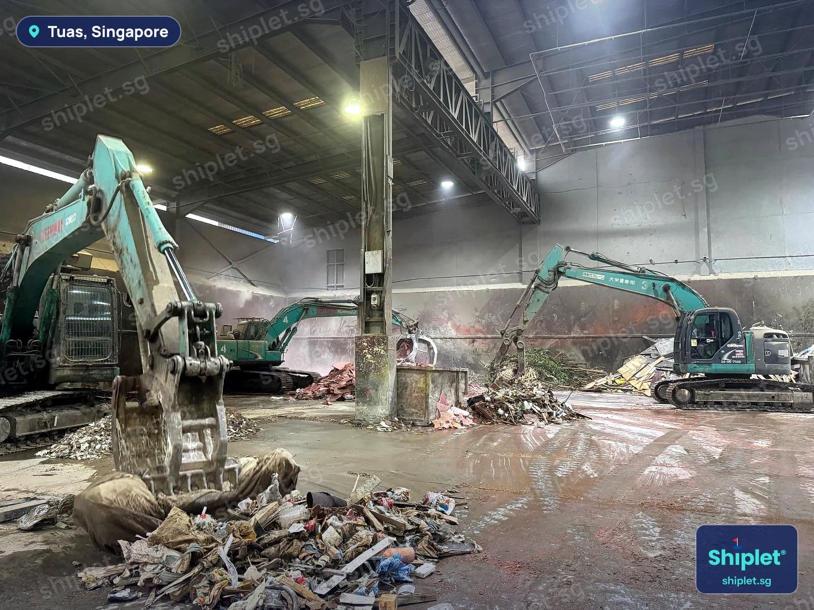 Excavators sorting mixed waste on the floor of a licensed disposal facility in Tuas, Singapore